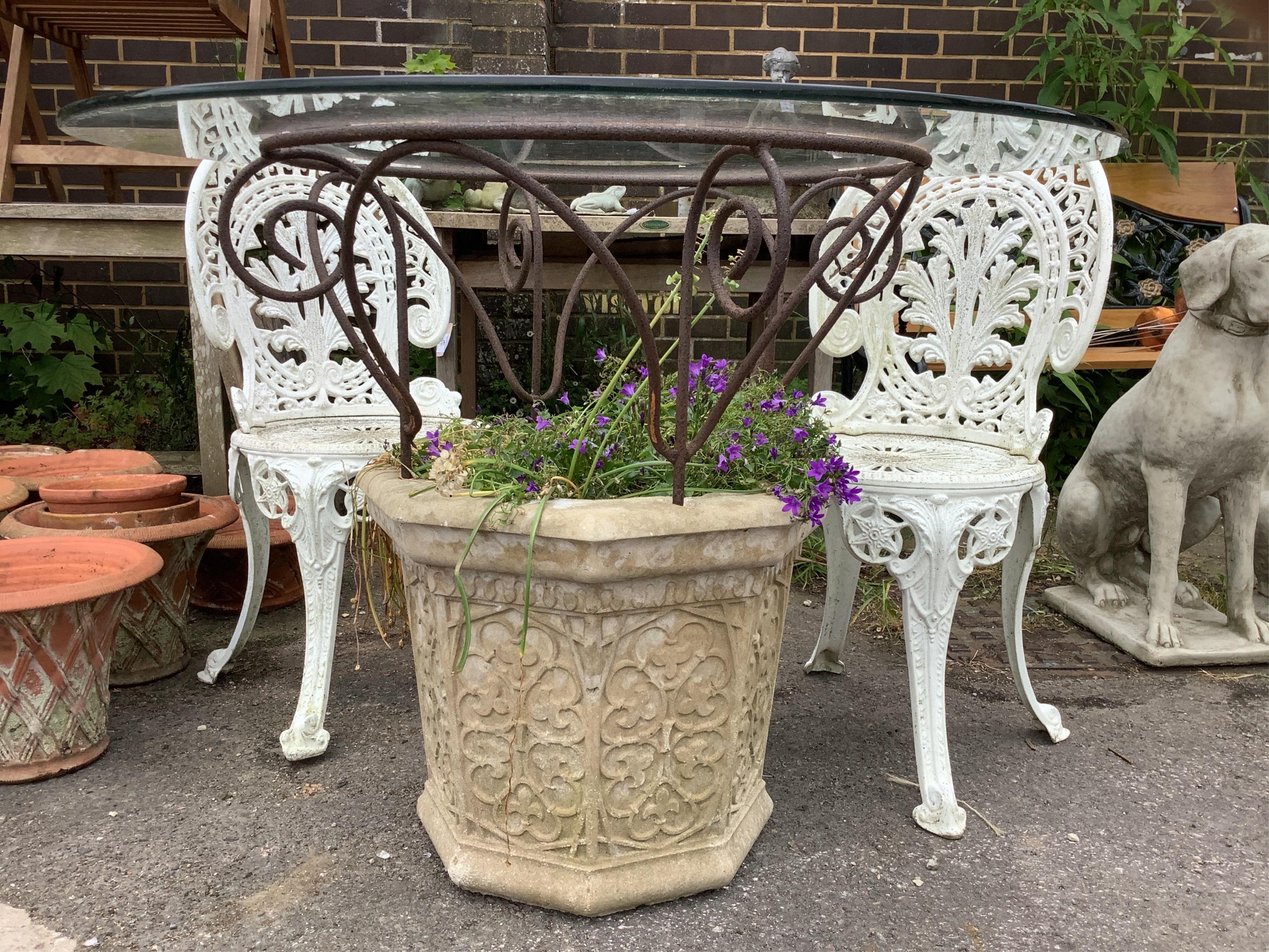 A reconstituted stone and wrought iron glass top garden planter/table, diameter 100cm, height 77cm, together with a pair of aluminium chairs. Condition - good